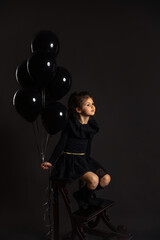 Fototapeta na wymiar Artistic portrait of little girl holding balloons