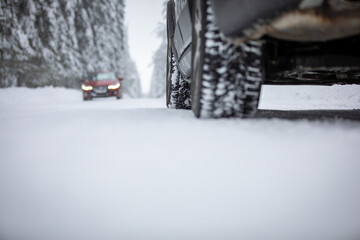 Car on a snowy winter road amid forests - using its four wheel drive capacities to get through the...