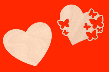 Two wooden hearts on a red background.