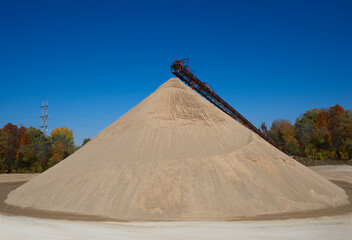 A very large cone shaped pile of sand.