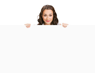 Cheerful smiling brunette woman standing behind, peeping from blank banner or mock up signboard, showing advertising copy space ad text area, isolated on white background.