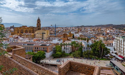 Fototapeta na wymiar Amazing panorama of Malaga city center, seaport and marina on a beautiful sunny day with blue sky above. Scenic view of the Malaga from the Alcazaba citadel located on the hills. Andalusia, Spain.
