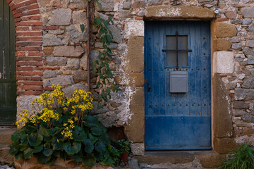 Blue wooden door in a stone house by the mediterranean sea.