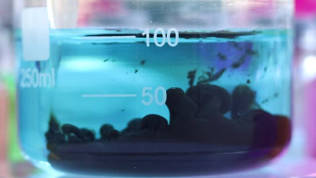 An interesting chemical reaction of the formation of an insoluble colloidal substance of black copper sulfide in a beaker.