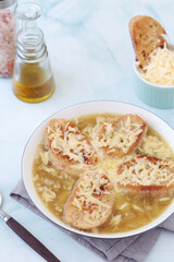A ceramic bowl with French onion soup	
