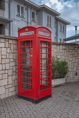 Gibraltar cityscape. Close up of empty typical English red telephone box close to Gibraltar Passport Control Station. UK                    
