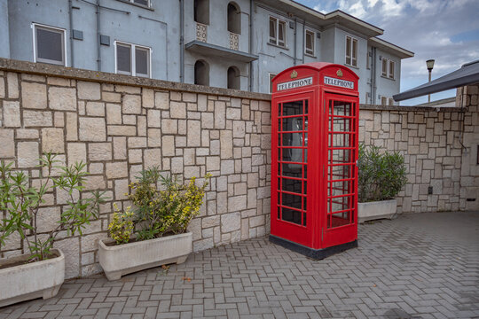 Gibraltar cityscape. Close up of empty typical English red telephone box close to Gibraltar Passport Control Station. UK                    