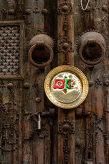 Algeria and Tunisia flag on a copper plate hanging on an old wooden door in the market in Tunis, Tunisia.