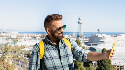 Happy man taking a selfie at a viewpoint in Barcelona (Spain), vacation concept.