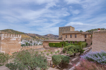 Amazing panorama of Granada city and Alhambra's Alcazaba fortress. Scenic view from Generalife gardens on a sunny day with blue sky above. Granada, Andalusia, Spain.                                   
