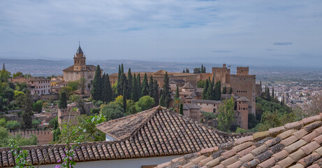 Naklejka premium Amazing panorama of Granada city and Alhambra's Alcazaba fortress. Scenic view from Generalife gardens on a sunny day with blue sky above. Granada, Andalusia, Spain. 