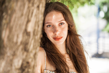 Close up portrait of a young beautiful girl in summer park