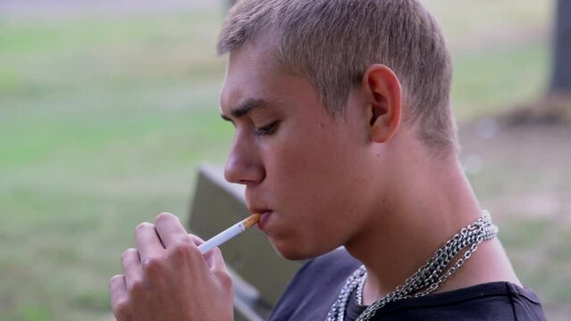 a young guy smokes a cigarette