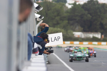 Obraz premium Kart racing - a man holding a placard with lap counting