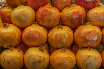 Close up of fresh pomegranates. Pomegranates in the market. Mediterranean food. Fresh pomegranates background for graphics designers.
