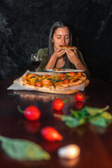 Woman enjoying a margherita pizza with a glass of wine