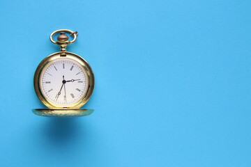 Blue background. Golden pocket watch on a blue background.