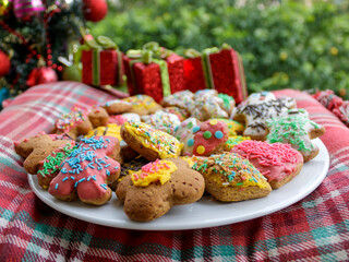Plate of homemade decorated cookies next to Christmas tree