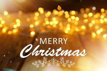 Merry Christmas. Blurred view of glowing festive lights on wooden table