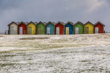 The colorful beach huts at Blyth beach surrounded by snow in a wintery Northumberland, England