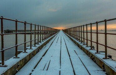 A freezing, snowy morning at Blyth beach at the old wooden Pier stretching out to the North Sea