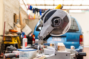 yellow miter saw on workbench next to more woodworking tool