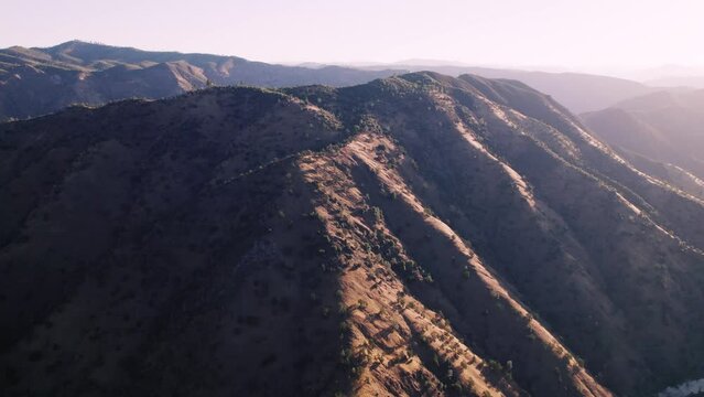 Rotating aerial shot of Californian mountain in early morning light. Dramatic landscape.