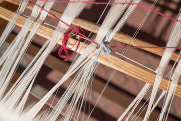 Part of an authentic loom of a weaver with threads, close-up.