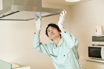 キッチンで換気扇を確認する男性作業員
