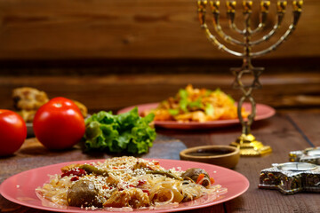Set table for Shabbat family meal with traditional food, fruits, burning candles and menorah.