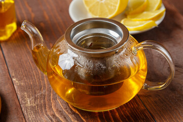teapot of lemongrass tea on a wooden table set for tea drinking.