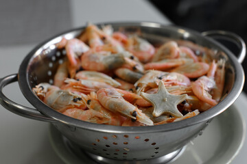 Shrimp and one starfish in a mettalic colander