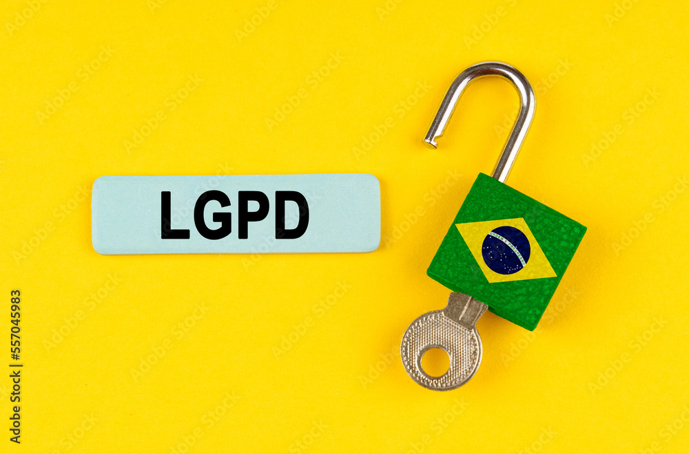 Poster on the yellow surface is an open lock with a key and a sticker with the inscription - lgpd