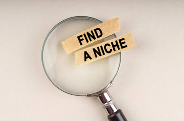 On the magnifying glass are paper strips with the inscription - Find a niche