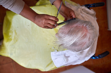 caregiver, cutting her elderly woman hair