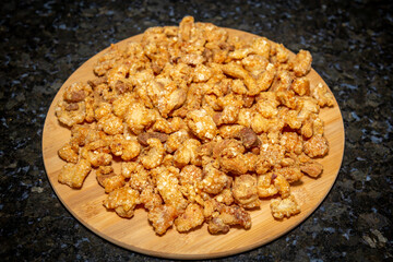 Crispy and fresh pork rinds in selective focus. On black barckground
