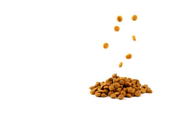 Pieces of dry food for cats and dogs fall on the table with food on a white background.