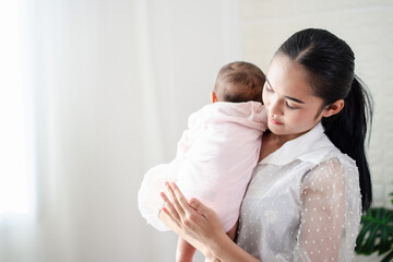 Mother Parenting and newborn birth life. Mom and baby boy playing in sunny bedroom, Family having fun together. childcare, maternity concept.