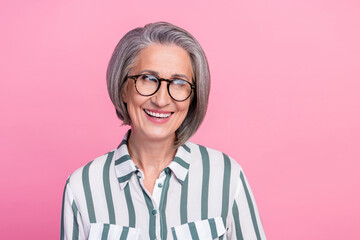 Photo portrait of mature aged retired businesswoman smile look empty space wear eyeglasses new company ad isolated on pink color background