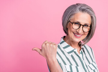 Photo of pensioner cheerful woman executive director indicate thumb empty space useful tips present...