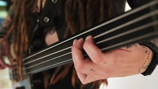 Woman bass guitarist playing the bass guitar. Dreadlocks