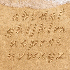 Fototapeta na wymiar The alphabet written in sand on a beach.