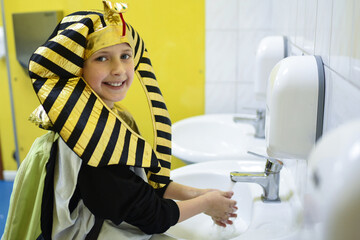 child dressed as a pharaoh washes his hands