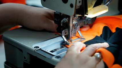 tailor is sewing fabric on the sewing machine