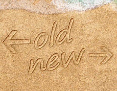 old vs new life change concept written on sand