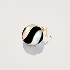 Fototapeta premium Black and white striped bauble, Christmas decoration, creative layout, winter holidays inspiration. 