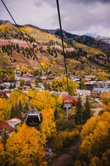 Landscape of sceneic views in Telluride, Colorado in the fall with colorful aspen trees, gondola, and purple mountain background