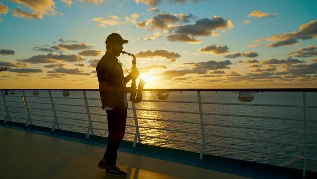 Sax at sunset near railing of upper deck