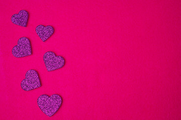 Glittering purple hearts on magenta background. Valentines day concept. Copy space. Flat lay.