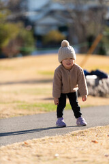 冬の公園で散歩しているニット帽をかぶった子供